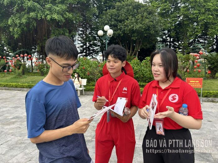 Các tình nguyện viên Hành trình Đỏ tham gia tuyên truyền, phát tờ rơi đến người dân tại Công viên Chi Lăng, phường Lương Văn Tri