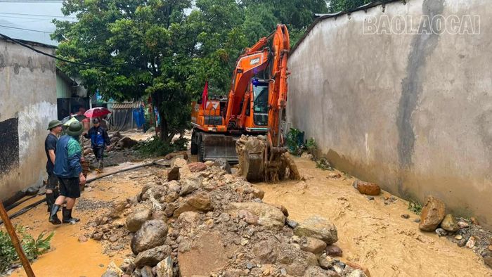 Máy xúc được huy động để hót dọn đất, đá sau mưa lũ. Ảnh: Xã Minh Lương
