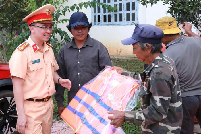 Trung tá Trần Đăng Khoa, Đội trưởng Đội CSGT đường thủy số 3, trao áo phao cứu sinh, vận động người dân hình thành thói quen mặc áo phao khi tham gia giao thông đường thủy
