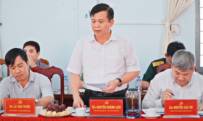 Đồng chí Nguyễn Hoàng Lịch, Phó Bí thư Đảng ủy, Chủ tịch UBND xã báo cáo với đoàn công tác