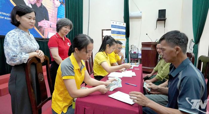Người dân xã Hợp Thành nhận tiền hỗ trợ.