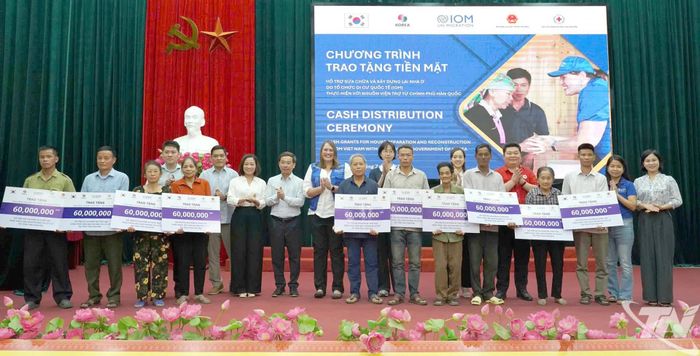 Đại diện các đơn vị tài trợ và lãnh đạo địa phương trao tiền hỗ trợ cho các hộ dân bị thiệt hại do bão, lũ tại xã Hợp Thành.