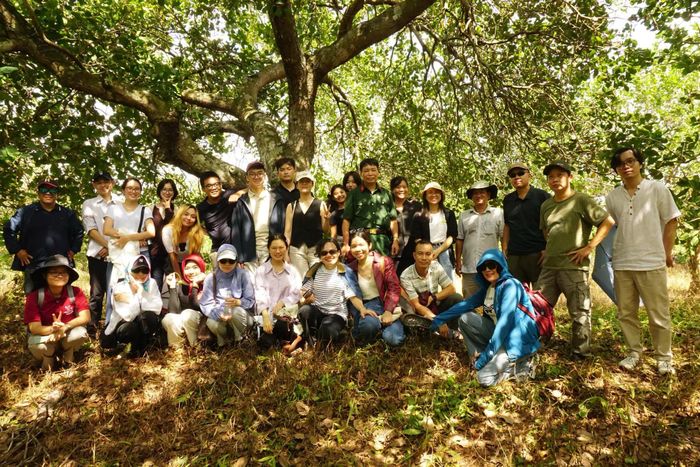 Các thành viên trong đoàn bên cạnh một hố bom trong rừng cao su, tại di tích sân bay quân sự Lộc Ninh.