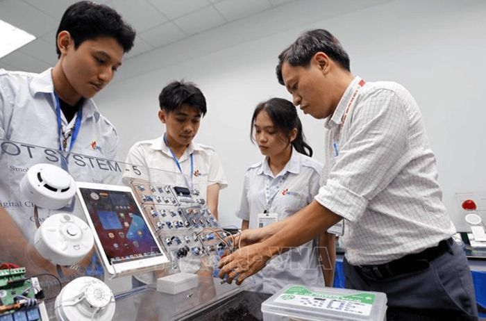 Giảng viên Khoa công nghệ điện tử, Trường Đại học Công nghiệp Thành phố Hồ Chí Minh hướng dẫn sinh viên học tập, nghiên cứu tại Phòng thí nghiệm IoT and AI. Ảnh minh họa: Thanh Vũ/TTXVN