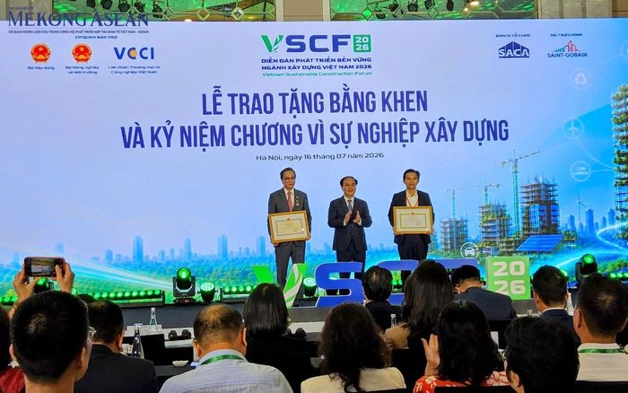 Thứ trưởng Bộ Xây dựng Nguyễn Văn Sinh trao bằng khen cho Hiệp hội Xây dựng và Vật liệu xây dựng TP HCM (SACA) và Chủ tịch Hội Đinh Hồng Kỳ. Ảnh: Ngọc Linh