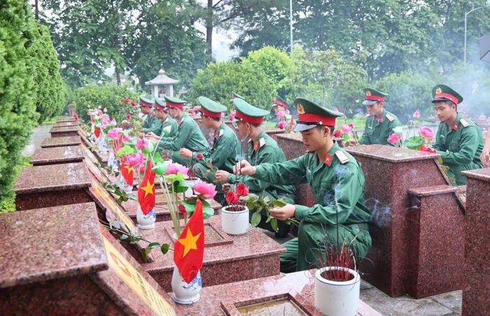 Các chiến sĩ Bộ Chỉ huy Quân sự tỉnh thắp hương và đặt hoa tại phần mộ liệt sĩ.