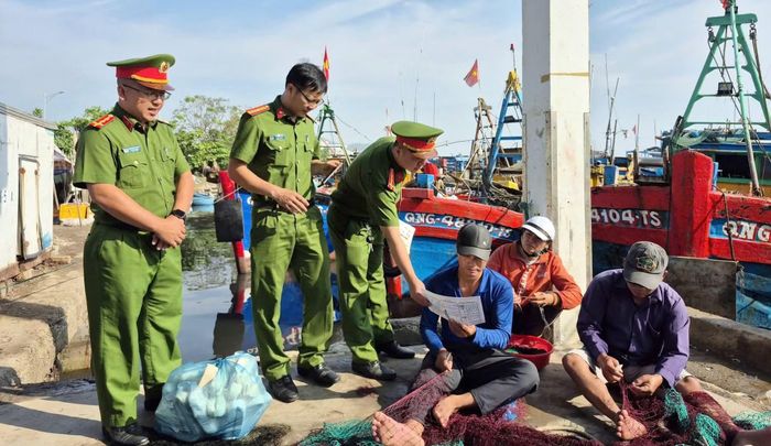 Cán bộ Phòng Cảnh sát PCCC và CNCH Công an tỉnh Quảng Ngãi phát tờ rơi tuyên truyền PCCC cho ngư dân.