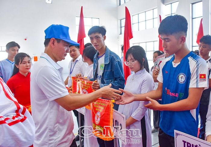 Ông Hứa Sít, Chủ tịch UBND xã Vĩnh Lợi, trao cờ lưu niệm cho các đoàn tham dự đại hội.