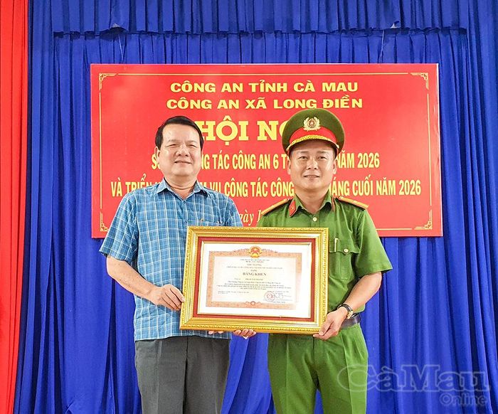 Bí thư Đảng ủy xã Long Điền Nguyễn Nam Quân, thừa ủy quyền trao Bằng khen của Thủ tướng Chính phủ cho Thiếu tá Phạm Tấn Thanh, Phó Trưởng Công an xã Long Điền.