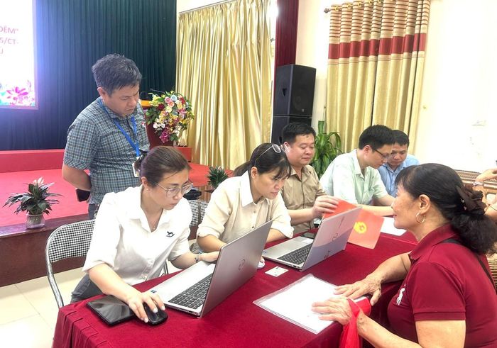 Người dân Tổ dân phố Việt Hưng 4 được tổ công tác hỗ trợ nhập dữ liệu lên hệ thống. Ảnh: B.Duy
