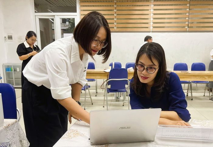 Chị Huyền được giáo viên hướng dẫn cụ thể từng bước kiểm tra thông tin và thao tác trên hệ thống. Ảnh: PV