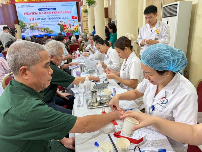 Các y, bác sĩ, lấy mẫu máu xét nghiệm cho đối tượng chính sách trong khuôn khổ chương trình. Ảnh: Hoa Thành