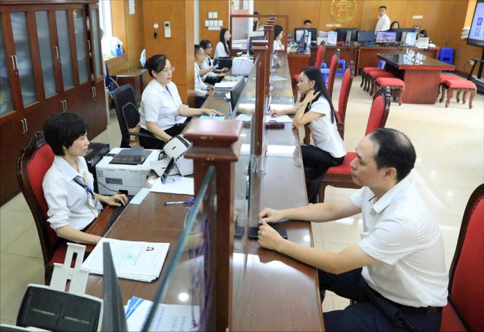 Cán bộ giải quyết thủ tục hành chính cho người dân tại Điểm phục vụ hành chính công Thanh Xuân (Hà Nội). Ảnh: Quang Thái