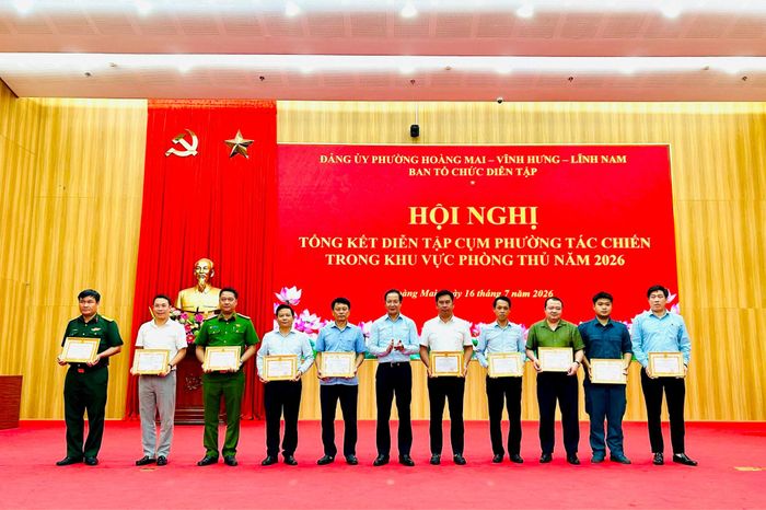 Bí thư Đảng ủy, Chủ tịch HĐND phường Vĩnh Hưng Nguyễn Đức Dũng khen thưởng các tập thể có thành tích xuất sắc nhiệm vụ diễn tập tác chiến trong khu vực phòng thủ năm 2026. Ảnh: Trần Oanh.
