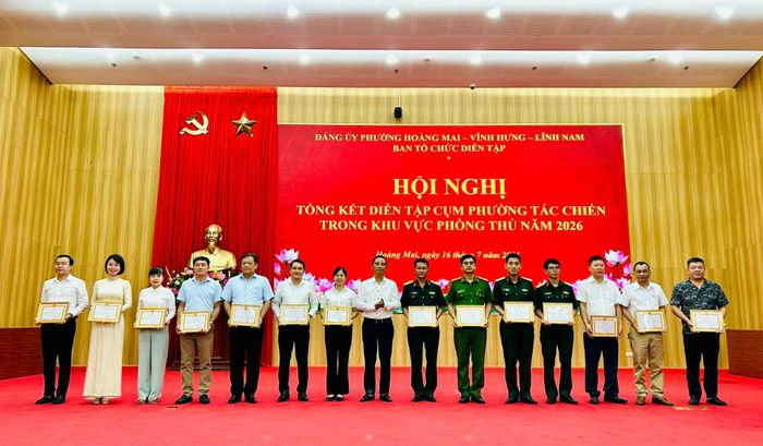 Bí thư Đảng ủy, Chủ tịch HĐND phường Hoàng Mai Nguyễn Xuân Linh trao Giấy khen cho các tập thể có thành tích xuất sắc nhiệm vụ diễn tập tác chiến trong khu vực phòng thủ năm 2026. Ảnh: Trần Oanh.