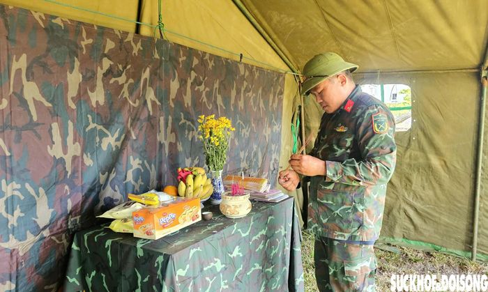 Các chiến sĩ thắp nén hương tại bàn thờ được đặt ở trong lán dựng tạm tại hiện trường.