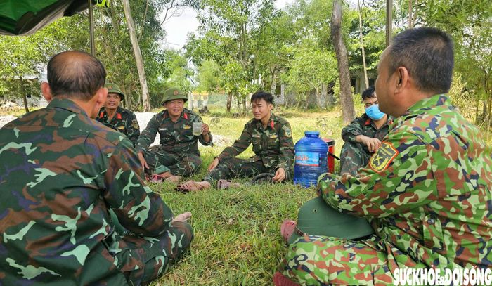  Sau nhiều giờ tìm kiếm trong nắng gắt, các chiến sĩ tranh thủ một khoảng nghỉ ngắn dưới lán dã chiến.