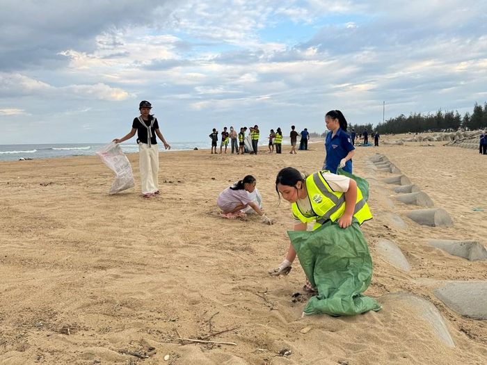 Các em học sinh nhặt từng mảnh rác trên bãi cát, góp phần hình thành ý thức sống xanh từ nhỏ