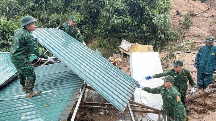 Chiến sĩ Đồn Biên phòng Pa Ủ giúp dân khắc phục hậu quả. Ảnh: TTXVN phát