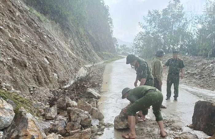 Lực lượng Công an xã Ngọc Chiến phối hợp bản Nậm Nghẹp thu dọn đất, đá sạt lở phía ta-luy dương xuống tuyến đường từ trung tâm xã lên bản.