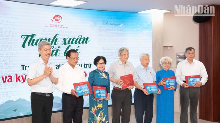 Cục trưởng Cục Văn thư và Lưu trữ Nhà nước Đặng Thanh Tùng trao tặng một số ấn phẩm về lưu trữ tặng đại diện các cán bộ đi B. (Ảnh MINH DUY)