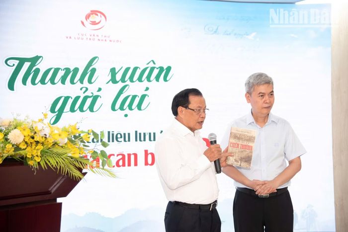 Ông Phạm Quang Nghị, nguyên Ủy viên Bộ Chính trị, nguyên Bí thư Thành ủy Hà Nội - một cán bộ đi B (trái) trao tặng lãnh đạo Cục Văn thư và Lưu trữ Nhà nước cuốn nhật ký, ghi chép về những năm tháng đi B mang tên “Nơi ấy là chiến trường”. (Ảnh: MINH DUY)