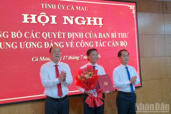Bí thư Tỉnh ủy Cà Mau Nguyễn Hồ Hải (bên trái) và Phó Bí thư Tỉnh ủy Hồ Thanh Thủy (bên phải) trao quyết định và tặng hoa chúc mừng đồng chí Đoàn Việt Khoa, Bí thư Đảng ủy, Chủ tịch Hội đồng nhân dân xã Nguyễn Phích.