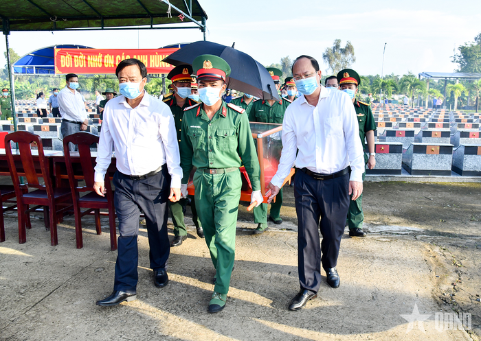  Các đại biểu thực hiện nghi thức quy tập hài cốt liệt sĩ sau khi hoàn thành việc lấy mẫu phục vụ giám định ADN. 