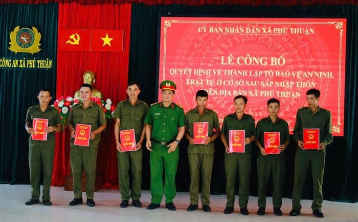 Chủ tịch UBND xã Nguyễn Thị Hồng, Thượng tá Trần Minh Quang - Trưởng Công an xã trao Quyết định thành lập mới 14 Tổ bảo vệ ANTT ở cơ sở tại 14 thôn.