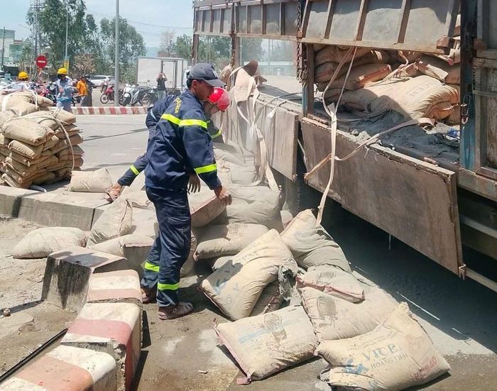 Cán bộ, chiến sĩ Đội Chữa cháy và Cứu nạn, cứu hộ hỗ trợ đưa xi-măng của xe gặp nạn ra khỏi hiện trường.