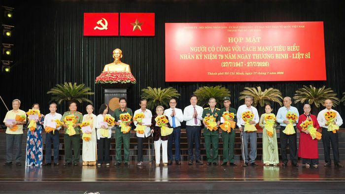  Phó Bí thư Thường trực Thành ủy TPHCM Lê Quốc Phong tặng hoa tri ân người có công với cách mạng. Ảnh: HOÀNG HÙNG 