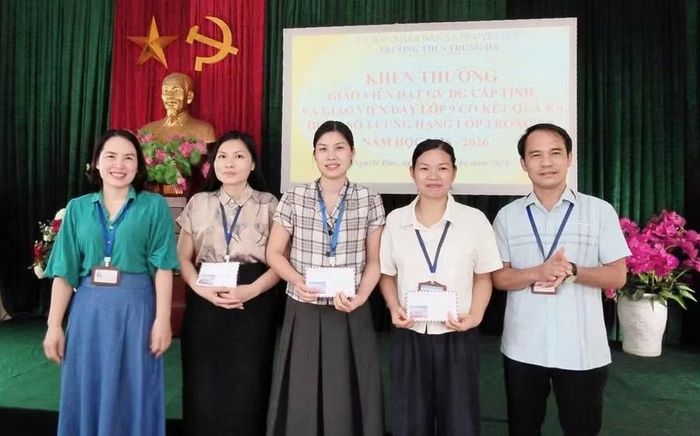 Ban giám hiệu nhà trường trao thưởng cho các giáo viên.