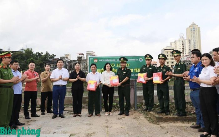 Đại diện Ủy ban nhân dân phường Móng Cái 2 tặng cờ Tổ quốc cho Đồn Biên phòng cửa khẩu quốc tế Móng Cái để treo thường xuyên trên tuyến đường thực hiện mô hình “Đường biên giới bình yên”. Ảnh: Xuân Quyết