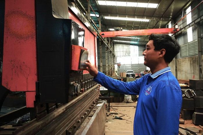 Anh Lê Anh Vũ, chủ DNTT cơ khí Thanh Cẩn điều khiển thiết bị chế biến thép sử dụng điện NLMTMN. (Ảnh: Đại Dương)