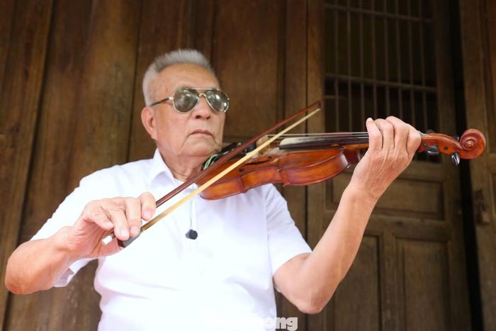 Dù không còn ánh sáng đôi mắt, ông Khoa vẫn say sưa chơi đàn.