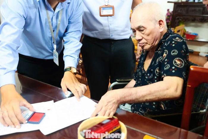 Từng giấy tờ được đối chiếu, kiểm tra kỹ lưỡng trước khi ông Phan Văn Đức và bà Đỗ Thị Trọng hoàn tất các thủ tục theo hướng dẫn của cán bộ.