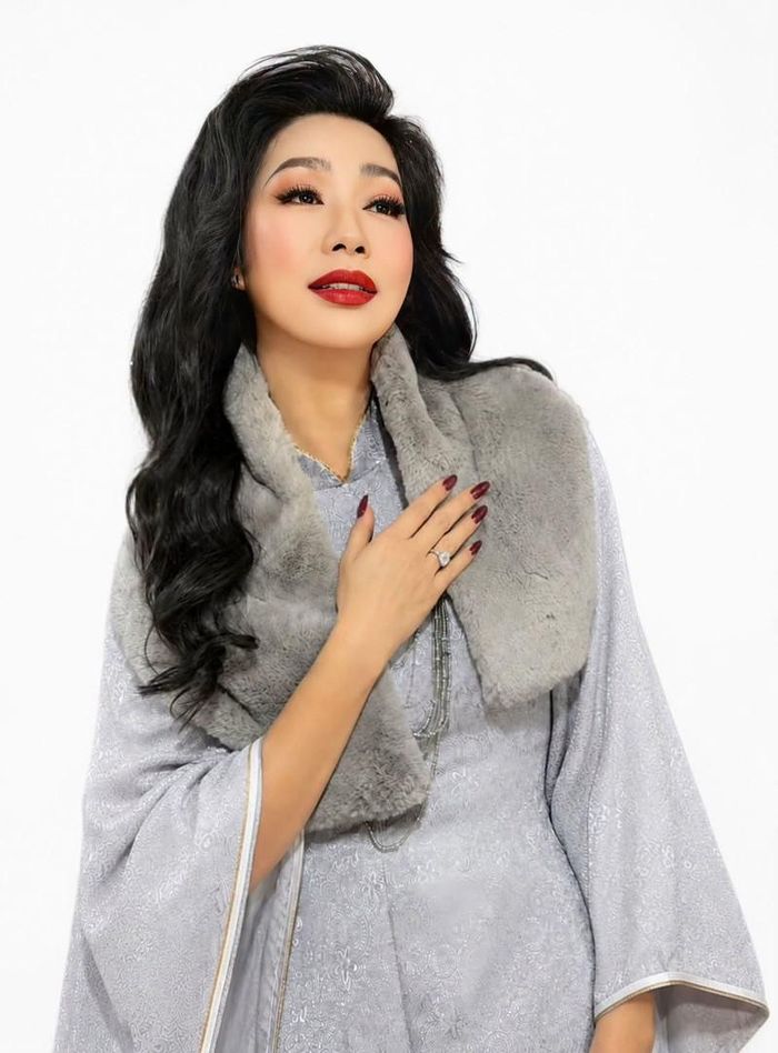NSND Trịnh Kim Chi khác lạ với son đỏ thắm, má hồng tươi và mái tóc xoăn. 