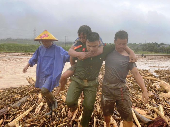 Đại úy Lù Văn Nến cán bộ Công an xã Mường Than cõng người bị thương vào bờ. Ảnh: A Chài