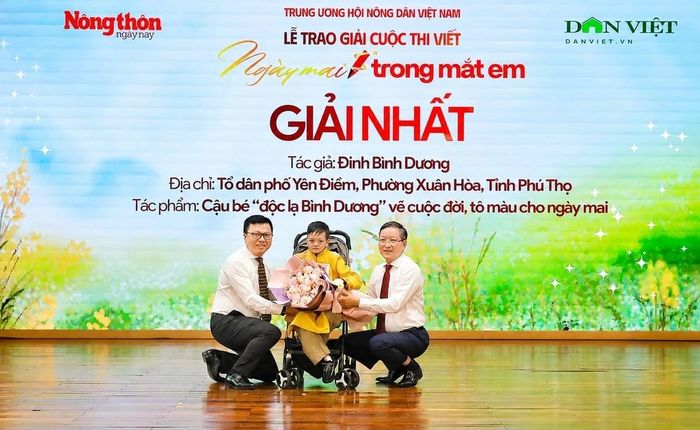 Ủy viên Trung ương Đảng, Phó Trưởng Ban Tuyên giáo và Dân vận Trung ương, Tổng Biên tập Báo Nhân Dân, Chủ tịch Hội Nhà báo Việt Nam Lê Quốc Minh và Ủy viên Trung ương Đảng, Phó Chủ tịch Ủy ban Trung ương Mặt trận Tổ quốc Việt Nam, Chủ tịch Ban Chấp hành Trung ương Hội Nông dân Việt Nam Lương Quốc Đoàn tặng hoa em Đinh Bình Dương - người đoạt giải Nhất cuộc thi với tác phẩm "Cậu bé độc lạ Bình Dương vẽ cuộc đời, tô màu cho ngày mai". Ảnh: Thanh Ngọc.