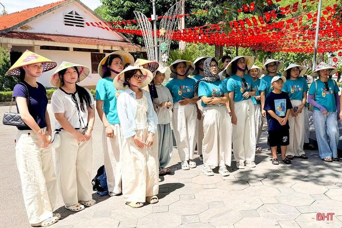 Du khách chăm chú trước bức thư chị Võ Thị Tần gửi mẹ tại Ngã ba Đồng Lộc.
