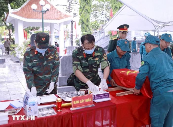 Lực lượng chức năng tỉnh Phú Thọ thực hiện quy trình lấy mẫu sinh phẩm ADN đối với hài cốt liệt sĩ chưa xác định danh tính tại Nghĩa trang Liệt sỹ Định Trung, phường Vĩnh Phúc. (Ảnh: Nguyễn Thảo/TTXVN)
