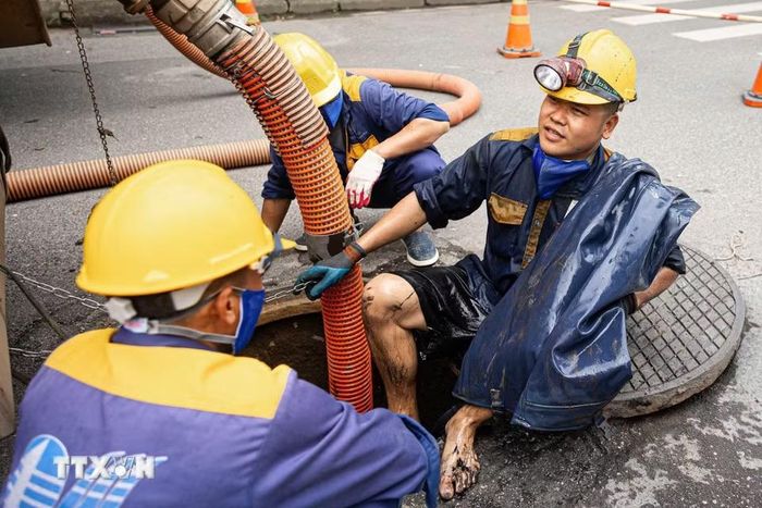 Kết thúc một ca làm thu gom rác dưới cống ngầm của các công nhân Công ty TNHH MTV Thoát nước Hà Nội. (Ảnh: Tiến Long/TTXVN phát)