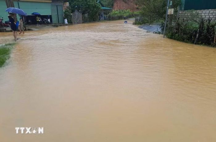 Nước ngập tại Km16+00, Tỉnh lộ 141B, xã Mường Phăng, các phương tiện phải tạm dừng lưu thông. (Ảnh: TTXVN phát)
