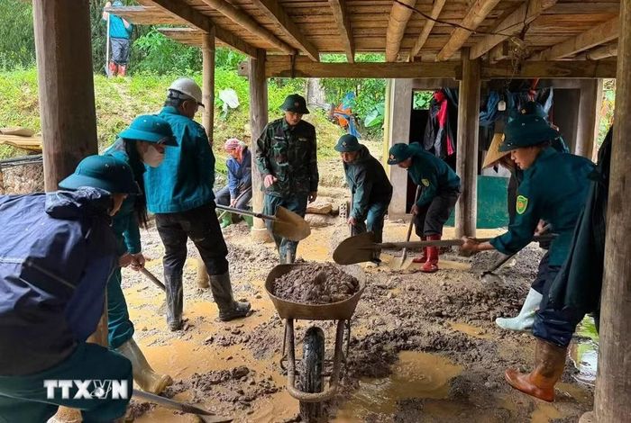 Các lực lượng chức năng hỗ trợ người dân khẩn trương khắc phục hậu quả thiên tai. (Ảnh: TTXVN phát)