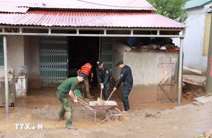 Lực lực Công an tỉnh Lai Châu hỗ trợ giúp dân khắc phục hậu quả mưa lũ. (Ảnh: Quý Trung/TTXVN)