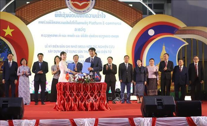 Doanh nghiệp hai nước Việt Nam - Lào trao đổi văn kiện ký kết hợp tác. Ảnh: Xuân Tú/PV TTXVN tại Lào