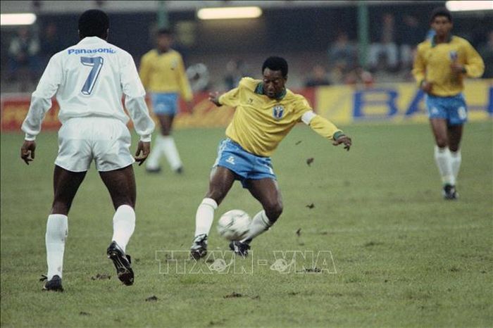Huyền thoại bóng đá Brazil Pele (trái) đi bóng trong trận đấu giao hữu của đội tuyển các ngôi sao bóng đá thế giới với tuyển Brazil nhân ngày sinh nhật thứ 50 của ông ở Milan (Italy) ngày 31/10/1990. Ảnh minh họa: AFP/TTXVN