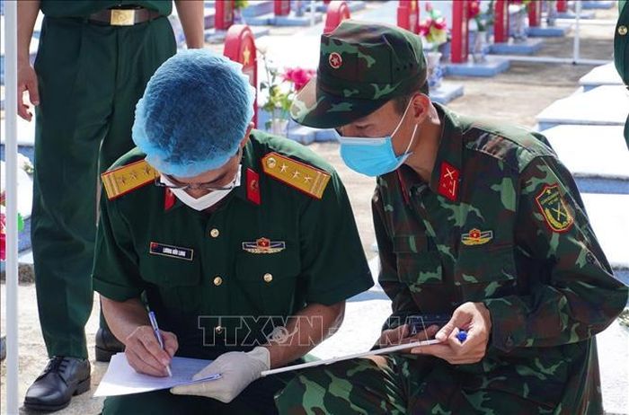 Cán bộ, chiến sĩ ghi chép đầy đủ thông tin để lập hồ sơ số các phần mộ liệt sĩ. Ảnh: Tường Quân/TTXVN
