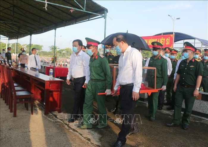 Lãnh đạo tỉnh Cà Mau di chuyển hài cốt liệt sĩ đến điểm lấy mẫu ADN tại Nghĩa trang liệt sĩ xã Phước Long. Ảnh: Tuấn Kiệt/TTXVN