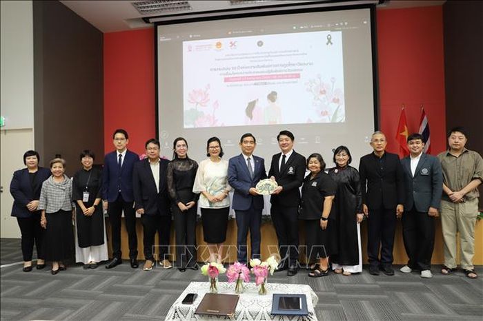 Đại sứ Phạm Việt Hùng chụp ảnh lưu niệm với đại diện Nhà trường và các diễn giả, khách mời tại hội thảo. Ảnh: Đỗ Sinh/TTXVN
